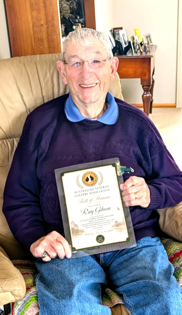 Ray Gibson holding up his framed Roll of Honour certificate
